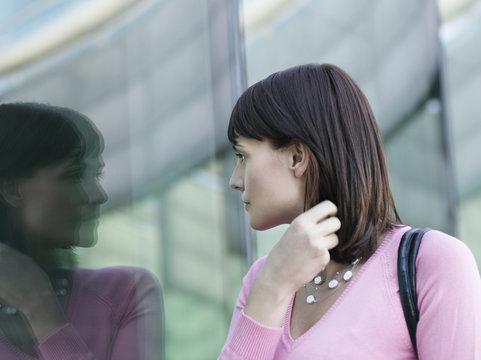 Young Businesswoman Looking At Reflection Of Self In Window