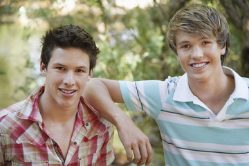 Portrait of two teenage boys smiling in forest