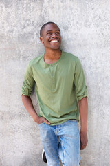 smiling young african American man leaning against wall