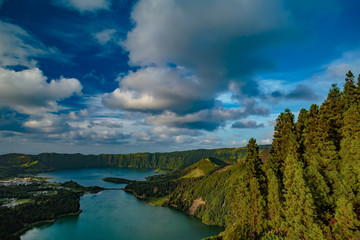 Mountain landscape in green valley with green lake in Azores island mountains with beautiful clouds at sunset time