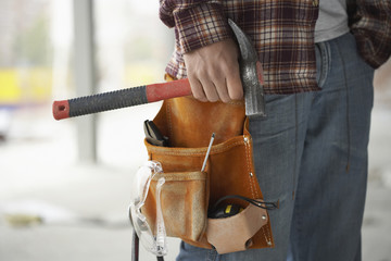 Closeup midsection of a male construction worker wearing tool belt