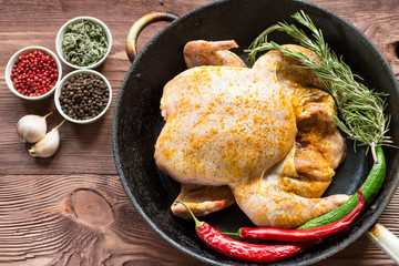 Whole roasted chicken with vegetables in cast-iron pan