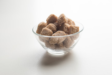 Cane sugar cubes heap close up macro shot on white table