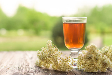 Glass of tea on table with herbs