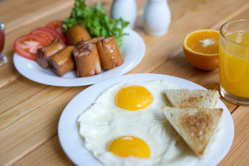 Orange juice, Two eggs and sausage for healthy breakfast.