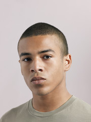 Obraz premium Closeup of young serious man looking at camera on colored background
