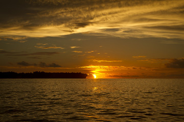 Sunset over Island Orange sky Water Clouds