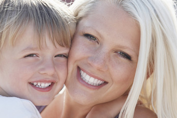 Closeup portrait of happy little boy and mother cheek to cheek