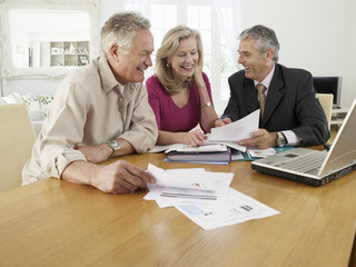 Mature couple sitting at table with financial advisor