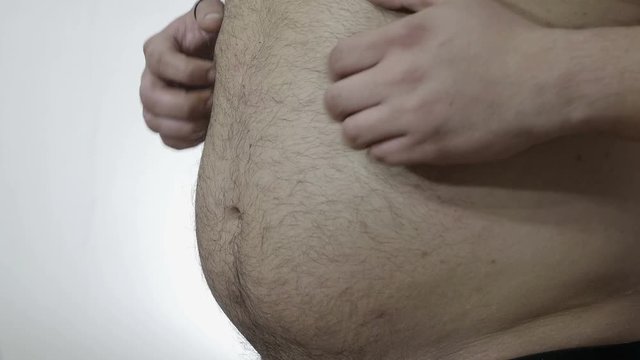 overweight problems: man hits his belly with his hands