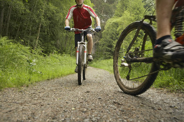 Naklejka premium Low angle view of two male cyclists on countryside track