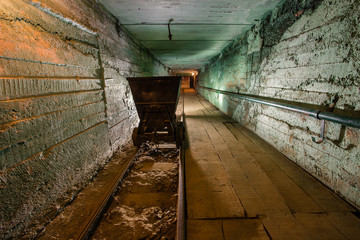 Mine tunnel with rails and orecart wagon