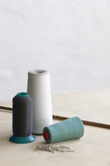 Spools of thead and pins on table