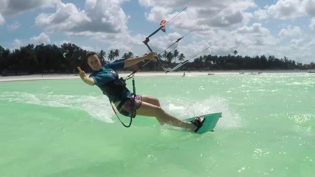 SLOW MOTION: Happy surfer girl kitesurfing in amazing blue Zanzibar lagoon
