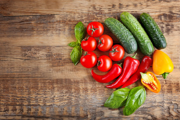 Fresh vegetables on wooden background, top view