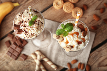 Delicious milkshakes on wooden background