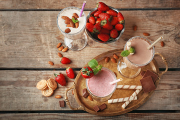 Delicious milkshakes on wooden background