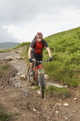 Fototapeta premium View of a male cyclist on countryside muddy track