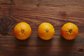 three organic oranges in a row of three