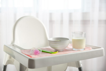 Highchair with healthy baby food at home. Child feeding concept