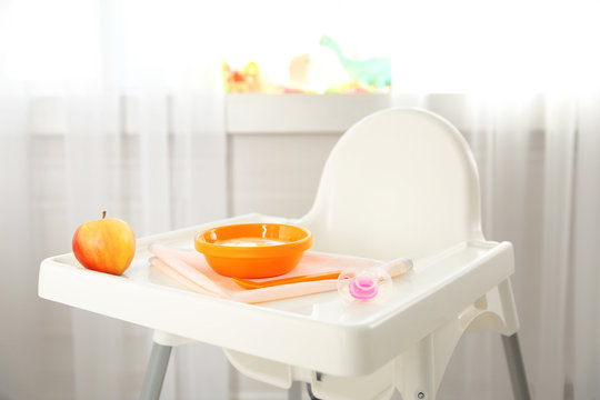 Highchair with healthy baby food at home. Child feeding concept