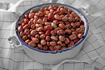 Bowl full of beans and napkin on a table