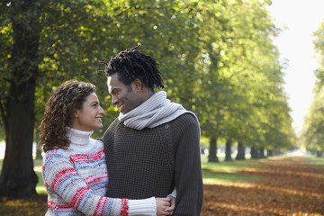 Fototapeta premium Romantic young couple looking at each other while embracing at park