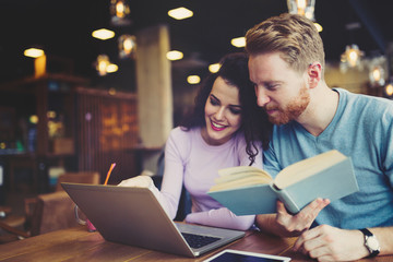 Happy couple studying in library