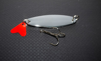 metal lure for catching fish on a black background © kvdkz