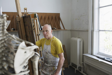 Portrait of a middle aged male artist painting in studio
