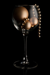 christmas card, wineglass with toys on black background isolated