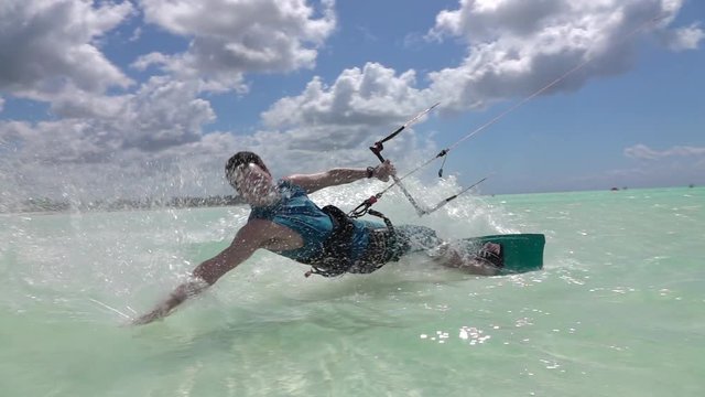 SLOW MOTION CLOSE UP: Cheerful surfer has fun kiteboarding in exotic island sea