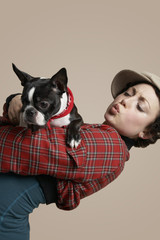 Beautiful young woman holding French Bulldog on colored background