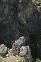 Elevated view of a relaxed couple sitting on rocks against mountains