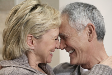 Side view closeup of romantic middle aged couple with heads together