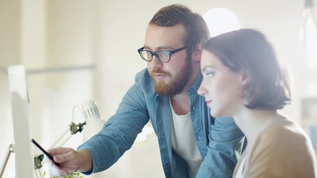  Young Woman and Bearded Man Sitting at Workingplace- Both Use Smartphones and Compare Something on Them. Shot on RED Cinema Camera in 4K (UHD).