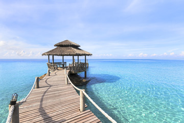 Beautiful tropical beach landscape, wooden pier, transparent turquoise sea water