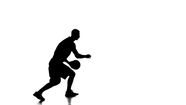 Boy basketball player makes a feint with the ball. Silhouette