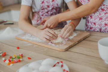 Mother with her daughter are preparing the buns