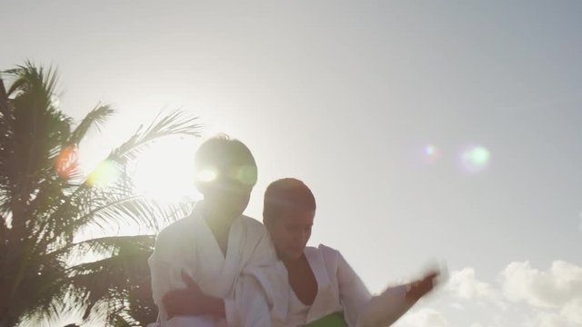 Young people, children, athletes, sport activity, combat and extreme sports, latino kids exercising in karate and traditional martial arts. Simulation of fight on the beach near the sea