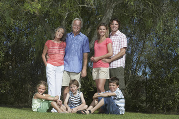 Full length portrait of three generation family under the tree