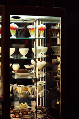 Glass stand with tasty sweets in cafe