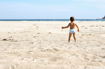 Boy running on beach sand