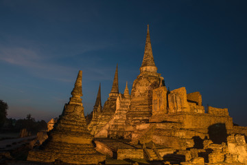 Fototapeta premium Ancient ruins of the temple Wat Phra Sri Sanphet national historic site with lights show at twilight time in Ayutthaya, Thailand.