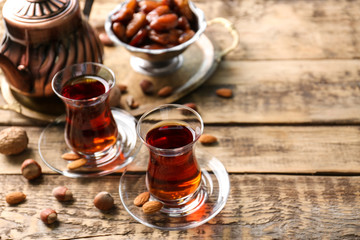 Turkish tea in traditional glasses with nuts on wooden background