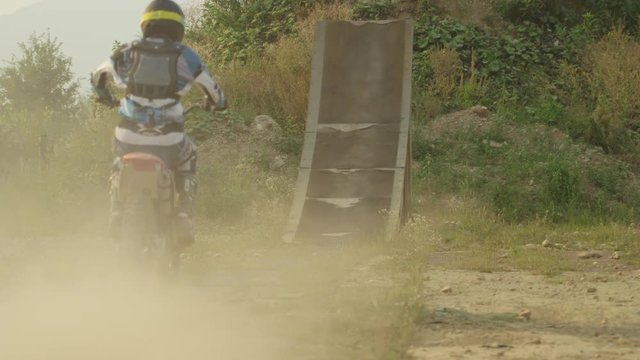 SLOW MOTION: Extreme pro motocross biker riding motorbike jumping big air trick