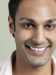 Obraz premium Closeup portrait of handsome young man smiling on colored background