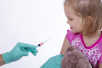 Doctor holds an injection vaccination little girl