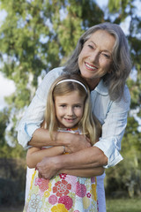 Portrait of a smiling grandmother with granddaughter outdoors
