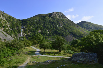 Fototapeta premium Wide landscape with Tropical waterfall and pathway leading to it on summers day, Aber falls abergwyngregyn wales